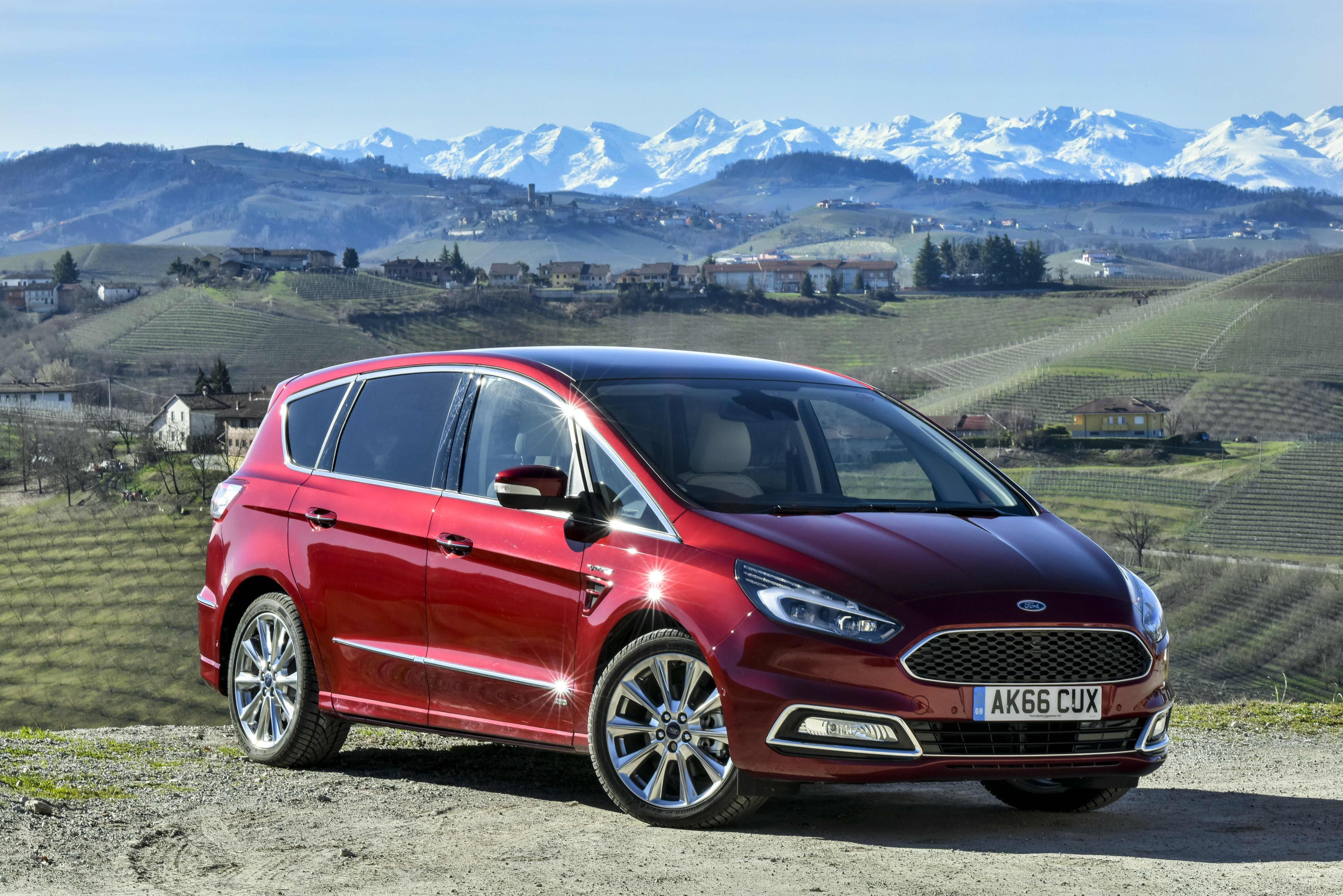 Dark red Ford S-Max parked facing three-quarters right on hill overlooking countryside.